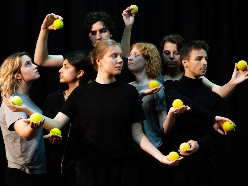 7 junge Menschen stehen zusammen, alle haben einen Tennisball in der Hand.