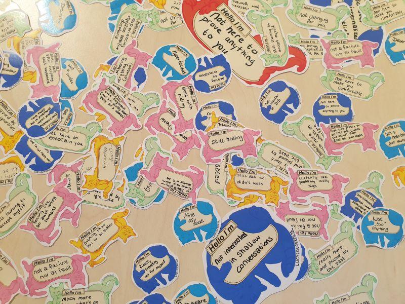 Viele Sticker auf einem Tisch, alles bunte Katzen mit kurzen Statements rund um Neurodivergenz.