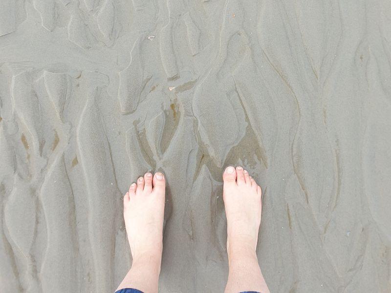 Paulas Füße am nassen Nordseestrand.