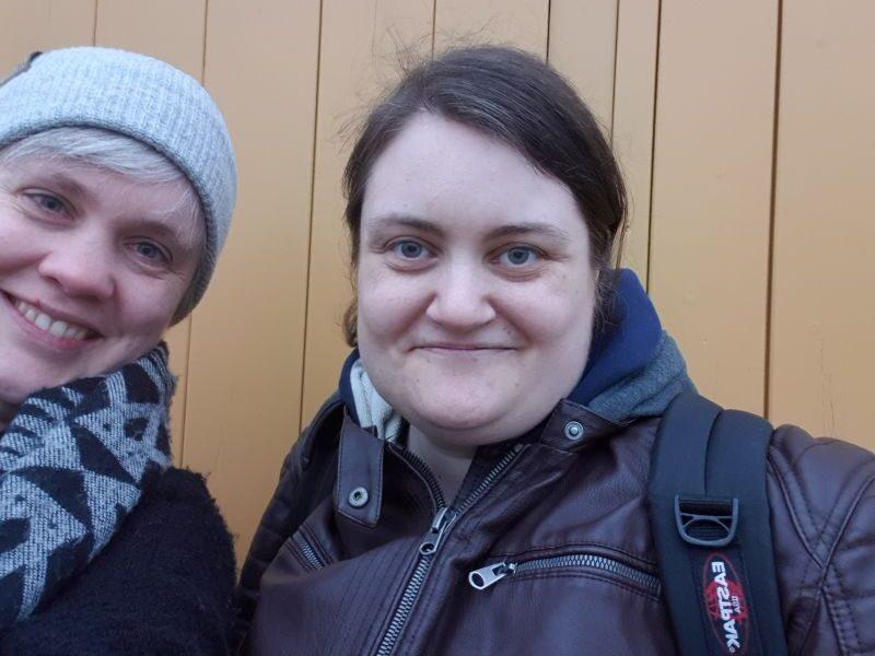 Paula und Mim vor einer gelben Wand.